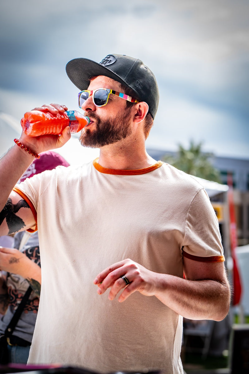 A customer outdoors drinking a bottle of Salacious Punch
