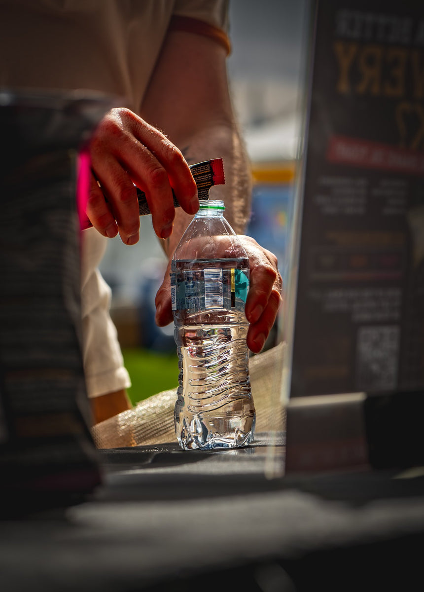 Tearing open a Snake Oil stick and pouring it into a bottle of cold water